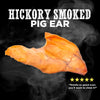 Image of a natural USA baked, hickory smoked pig ear with steam effect. Text: &quot;Hickory Smoked Pig Ears&quot; (Best Bully Sticks) and a five-star rating with the quote, &quot;Smells so good even you&#39;ll want to chew it!&quot; Perfect as a delightful dog treat!.