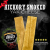 Two hickory smoked cheese sticks from the Hickory Smoked Sampler Box by Best Bully Sticks, ideal as a dog chew, featuring a ribbon emblem and five-star rating against a smoky backdrop. Text reads: &quot;Smells so good even you&#39;ll want to chew it!